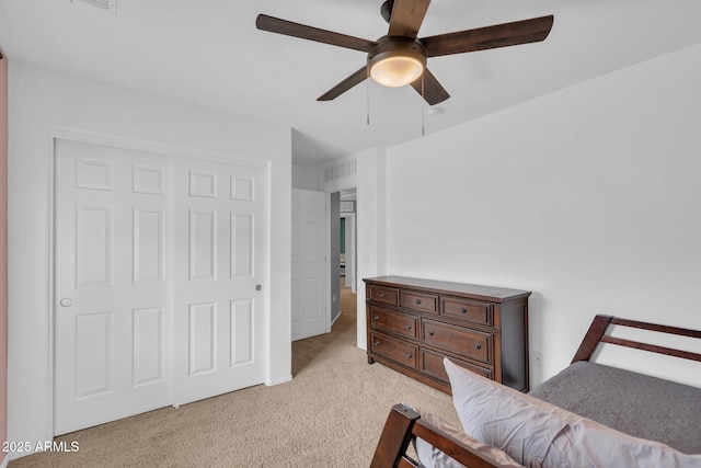 bedroom featuring light carpet, a closet, and a ceiling fan