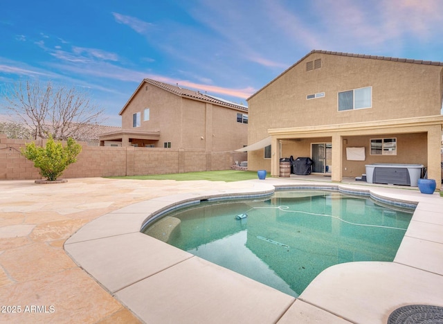 view of pool featuring a patio area, a jacuzzi, and a fenced backyard