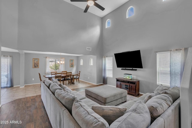 living room with visible vents, a healthy amount of sunlight, wood finished floors, and ceiling fan with notable chandelier