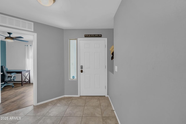 entrance foyer with light tile patterned floors, baseboards, and a ceiling fan