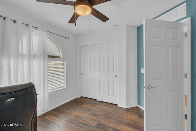 unfurnished office featuring dark wood-type flooring, baseboards, and ceiling fan