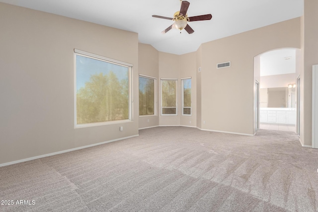 carpeted spare room featuring vaulted ceiling and ceiling fan