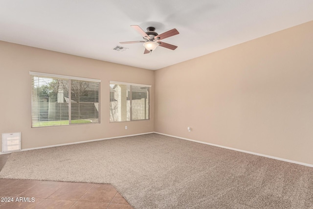 carpeted spare room with ceiling fan