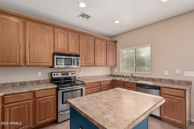 kitchen with a center island, light tile patterned flooring, sink, and stainless steel appliances