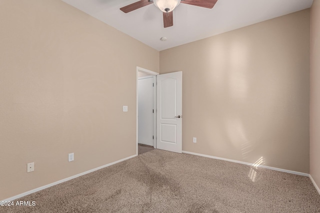 carpeted spare room with ceiling fan