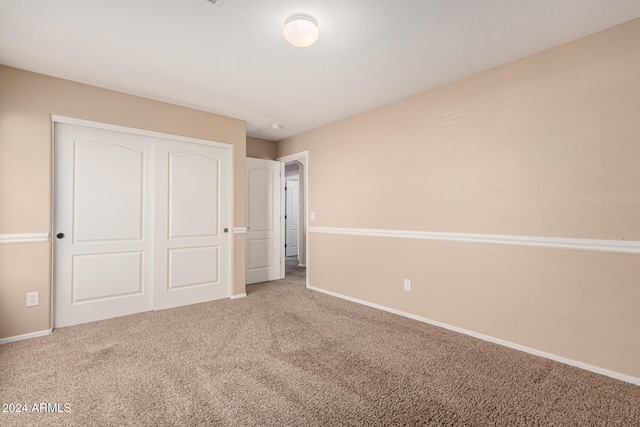 unfurnished bedroom featuring carpet and a closet