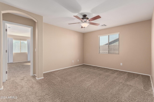 carpeted spare room with ceiling fan