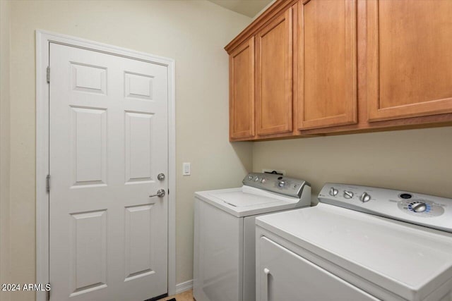 washroom featuring cabinets and washer and dryer