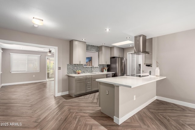 kitchen featuring a sink, ventilation hood, appliances with stainless steel finishes, gray cabinets, and decorative backsplash