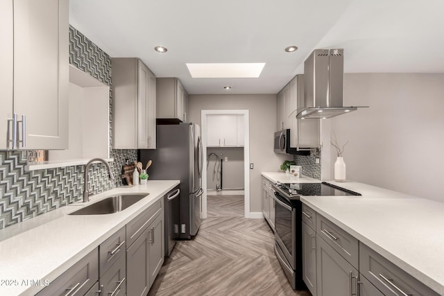 kitchen featuring stainless steel appliances, a sink, light countertops, ventilation hood, and gray cabinets