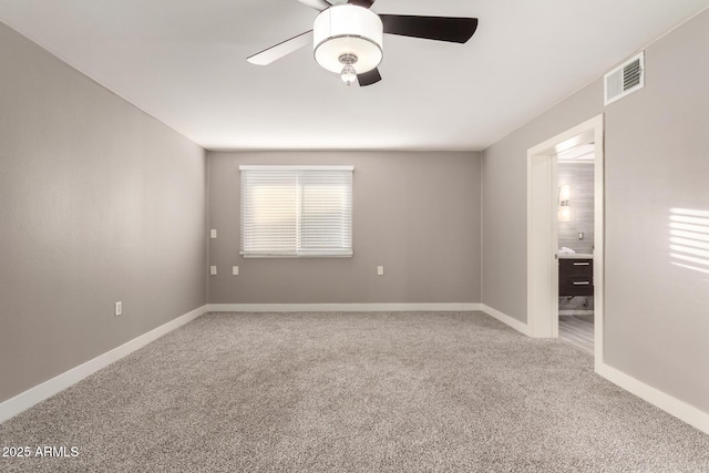 spare room featuring ceiling fan, carpet floors, visible vents, and baseboards