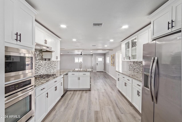 kitchen with kitchen peninsula, light hardwood / wood-style flooring, ceiling fan, white cabinetry, and stainless steel appliances