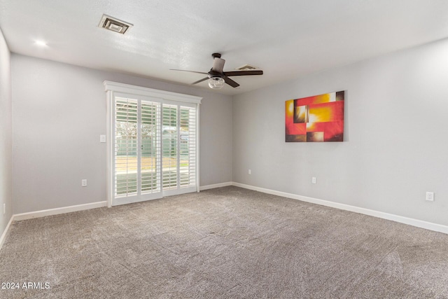 spare room with ceiling fan and carpet