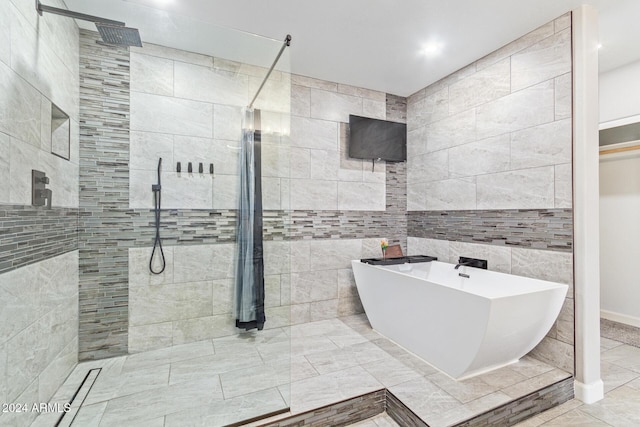 bathroom featuring separate shower and tub and tile walls