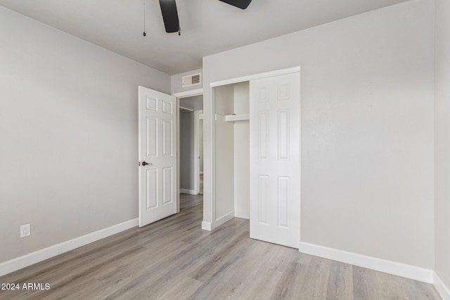 unfurnished bedroom with light hardwood / wood-style floors, a closet, and ceiling fan