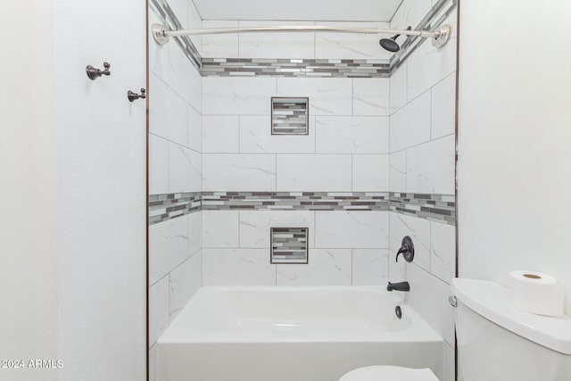 bathroom with toilet and tiled shower / bath