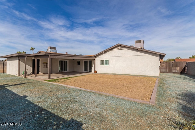 rear view of property featuring a yard and a patio area