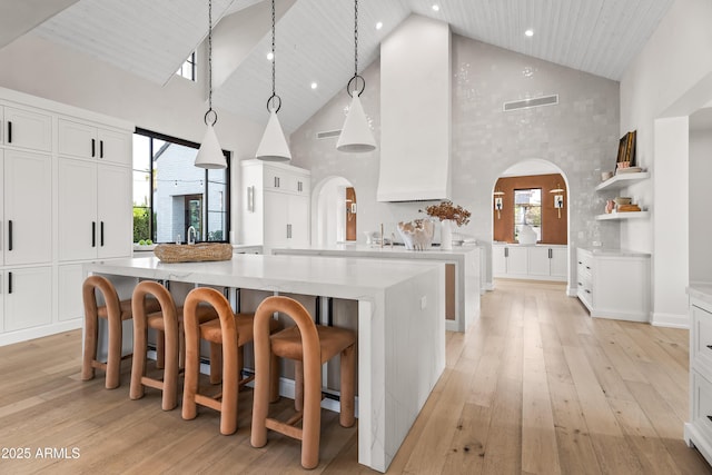 kitchen featuring pendant lighting, white cabinets, and a spacious island