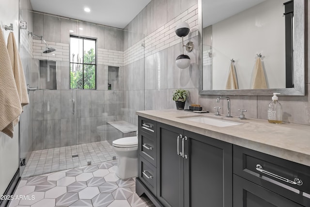 bathroom with vanity, backsplash, a shower with shower door, and tile walls