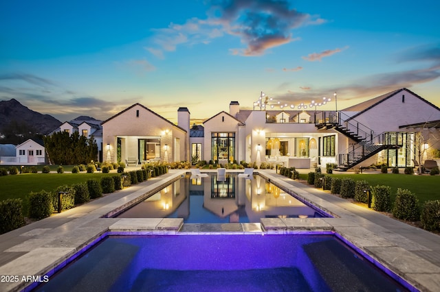 back house at dusk with a patio