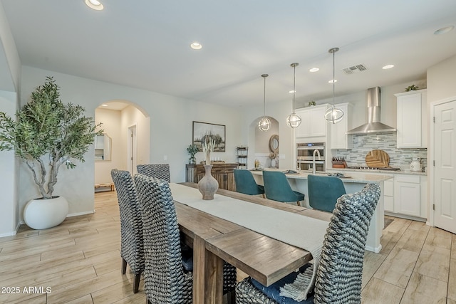 5759 W Saratoga Ct, Florence, AZ 85132 - dining space with arched walkways, light wood finished floors, recessed lighting, and baseboards
