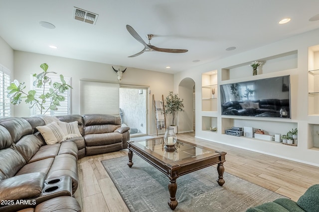 5759 W Saratoga Ct, Florence, AZ 85132 - living room featuring arched walkways, ceiling fan, wood finished floors, and built in shelves