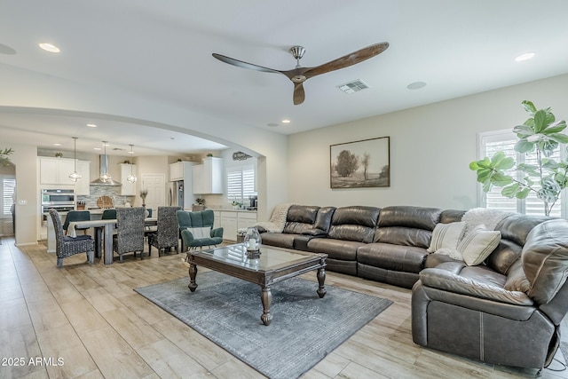 5759 W Saratoga Ct, Florence, AZ 85132 - living room featuring ceiling fan, light wood-style floors, arched walkways, and recessed lighting