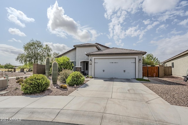 5759 W Saratoga Ct, Florence, AZ 85132 - view of property exterior featuring driveway, stucco siding, fence, a garage, and a tiled roof