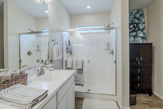 5759 W Saratoga Ct, Florence, AZ 85132 - bathroom with wood finished floors, a stall shower, vanity, baseboards, and recessed lighting