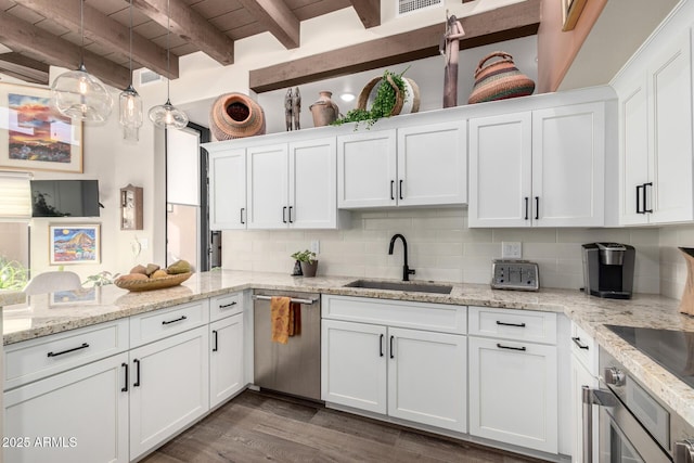 kitchen with sink, appliances with stainless steel finishes, hanging light fixtures, white cabinets, and decorative backsplash