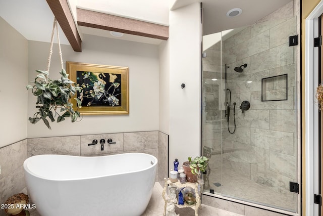 bathroom featuring beam ceiling, independent shower and bath, and tile walls