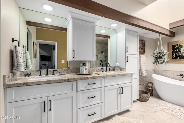 bathroom featuring vanity, independent shower and bath, and tile walls