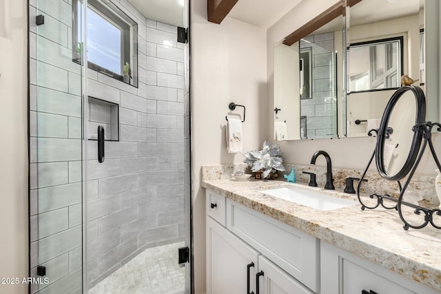 bathroom with vanity and a shower with door