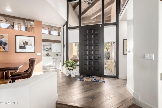 entrance foyer featuring hardwood / wood-style floors and beam ceiling