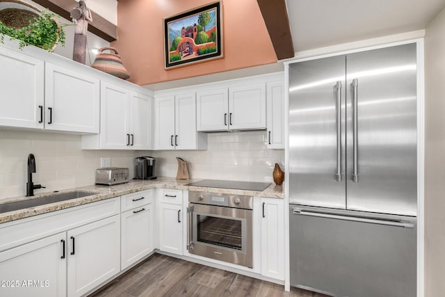 kitchen featuring white cabinetry, stainless steel appliances, sink, and backsplash