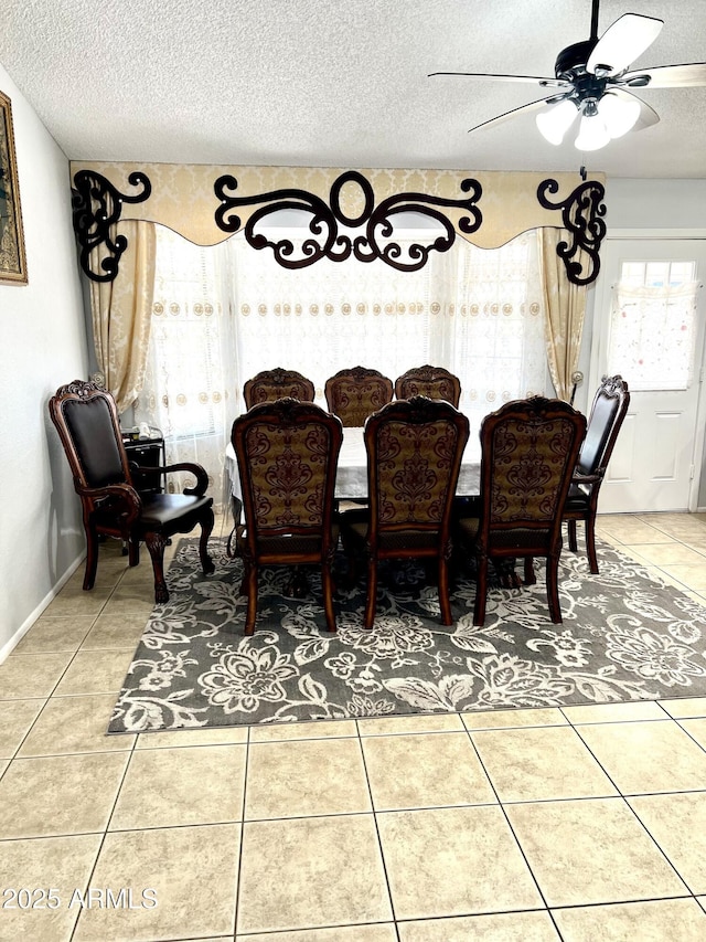 dining room with ceiling fan, tile patterned flooring, and a textured ceiling