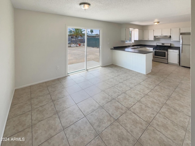 kitchen featuring plenty of natural light, stainless steel appliances, white cabinetry, and kitchen peninsula