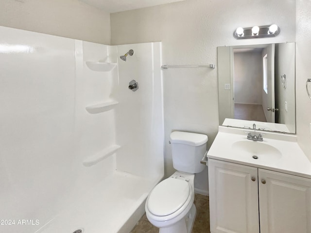 bathroom with vanity, toilet, and a shower