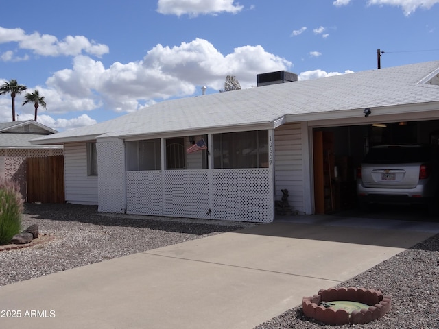 ranch-style house featuring driveway, roof with shingles, and an attached garage