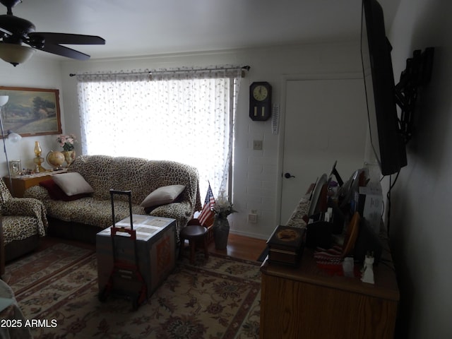 living area with a ceiling fan and wood finished floors