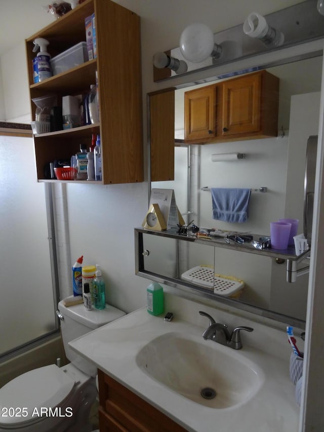 full bath featuring enclosed tub / shower combo, vanity, and toilet