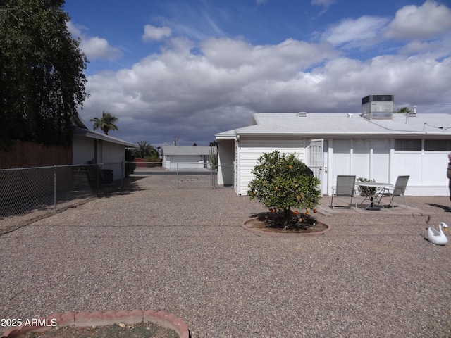 rear view of property featuring central AC, a patio area, and fence