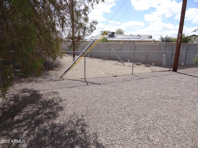 view of yard with central AC and fence