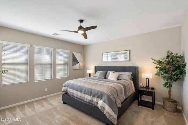 bedroom with baseboards, a ceiling fan, visible vents, and light colored carpet