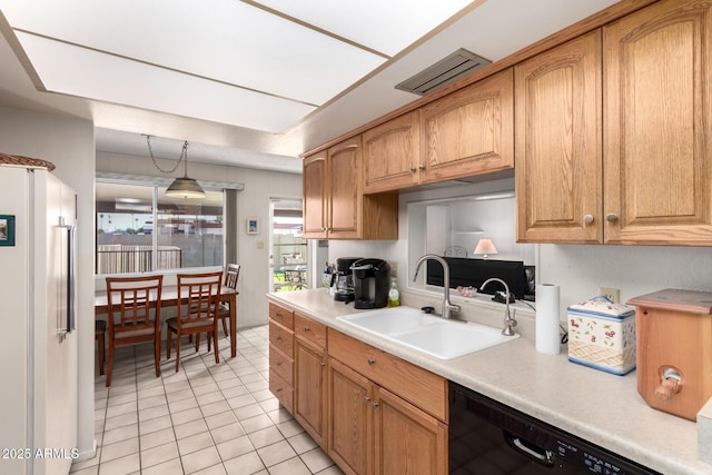 3901 W Augusta Ave, Phoenix, AZ 85051 - kitchen featuring a sink, freestanding refrigerator, black dishwasher, light countertops, and light tile patterned floors