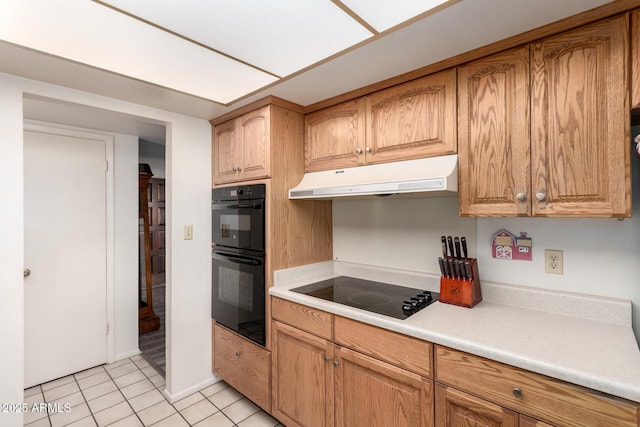 3901 W Augusta Ave, Phoenix, AZ 85051 - kitchen with under cabinet range hood, black appliances, light countertops, light tile patterned floors, and brown cabinetry