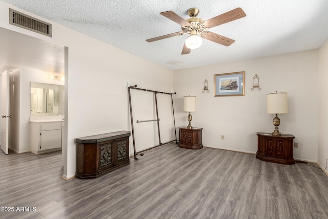 3901 W Augusta Ave, Phoenix, AZ 85051 - bedroom featuring wood finished floors, a textured ceiling, baseboards, ensuite bathroom, and ceiling fan
