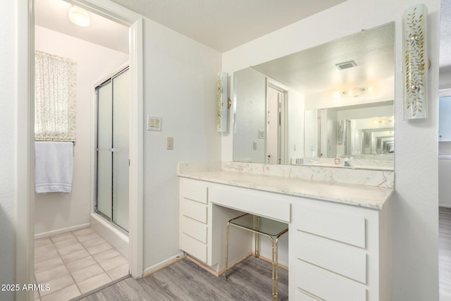 3901 W Augusta Ave, Phoenix, AZ 85051 - bathroom with a stall shower, baseboards, wood finished floors, and vanity