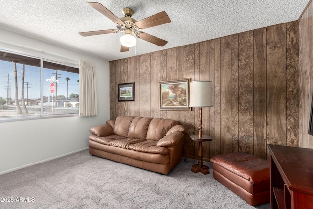 3901 W Augusta Ave, Phoenix, AZ 85051 - living area featuring wooden walls, carpet floors, a textured ceiling, a ceiling fan, and baseboards