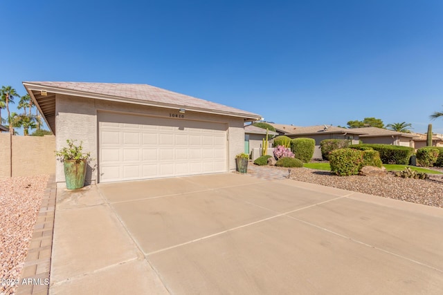 view of front of property featuring concrete driveway, an attached garage, and stucco siding